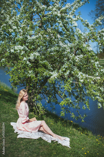 beautiful girl in dress sitting under the apple blossom © stock.film