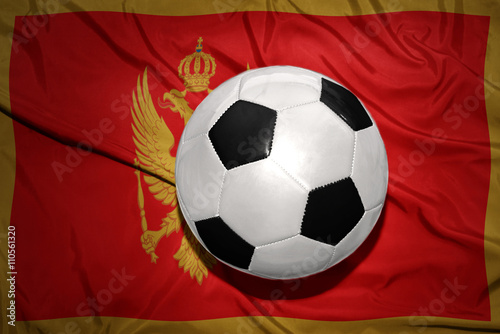 black and white football ball on the national flag of montenegro