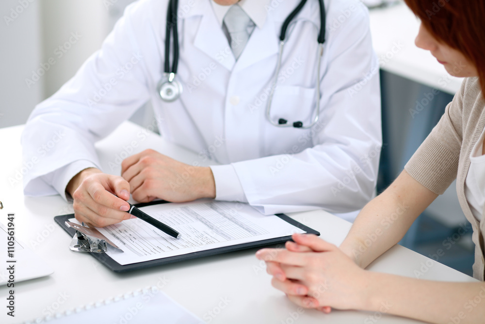 Doctor and patient are discussing something, just hands at the table Doctor and patient are discussing something, just hands at the table