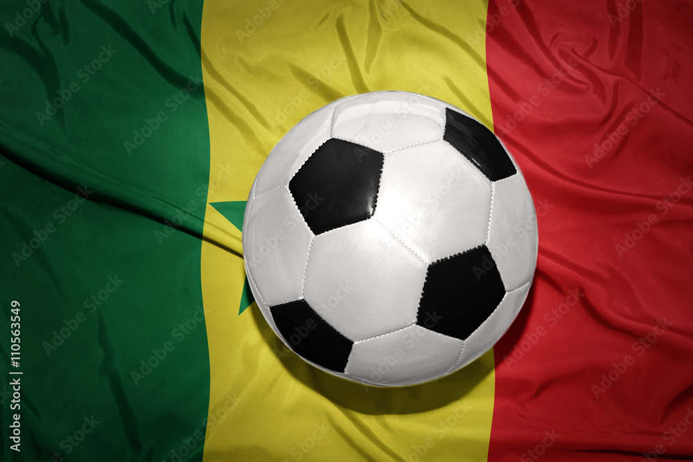 Naklejka premium black and white football ball on the national flag of senegal