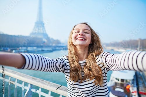 Young girl taking selfie near the Eiffel tower photo