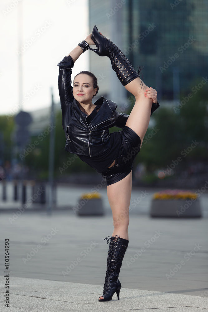 Beautiful woman performing acrobatics in the city