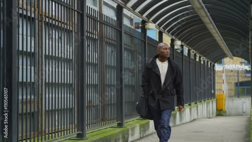 Wallpaper Mural  Serious man walking alone, away from railway station. Torontodigital.ca