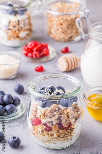 Healthy breakfast - glass jars of oat flakes with fruit, yogurt.