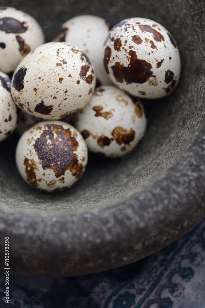 Obraz premium quail eggs in stone mortar