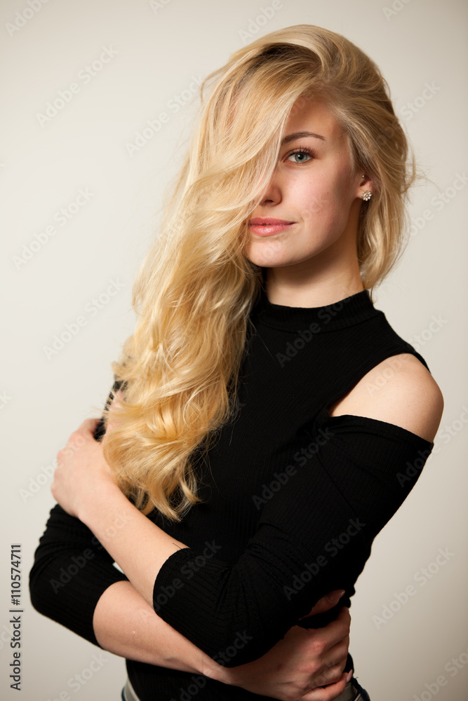 Fototapeta premium Beautiful young woman with gorgeous hairstyle posing over white