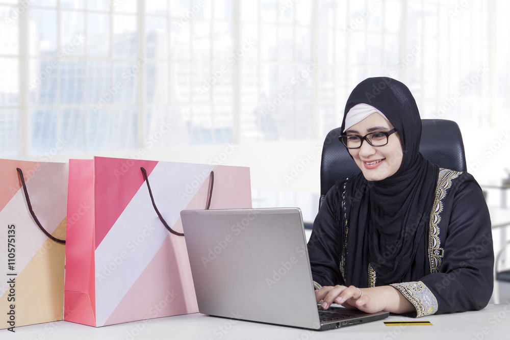 Arabian businesswoman shopping online in office