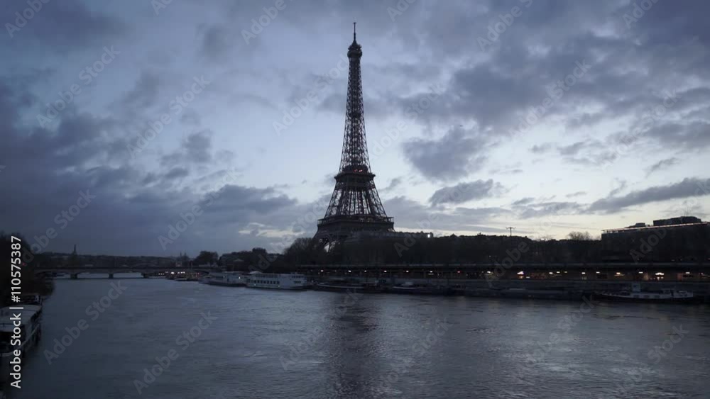 Eiffel Tower and Seine River in twilight just before sunrise with fast passing clouds. Paris, Port de Suffren, Grenelle, 7th Arrondissement. France Eiffel Tower and Seine River in twilight just before sunrise with fast passing clouds. Paris, Port de Suffren, Grenelle, 7th Arrondissement. France