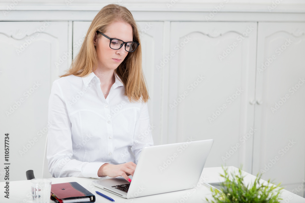 Young female working on laptop at the office  