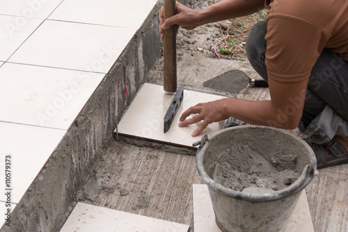 renovation - construction worker tiler is tiling, ceramic tile f