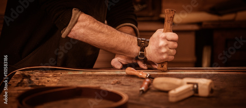 Leather goods craftsman at work in his workshop