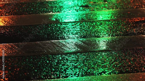 Rainy night in the city. Reflection of traffic lights changing from red to green