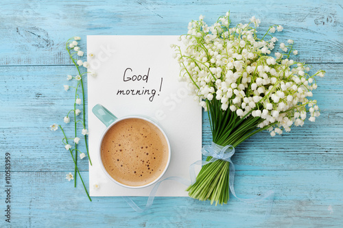 Stampa su tela Coffee mug with bouquet of flowers lily of the valley and notes good morning on