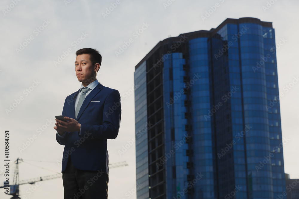 Korean businessman talking on phone in business district Korean businessman talking on phone in business district