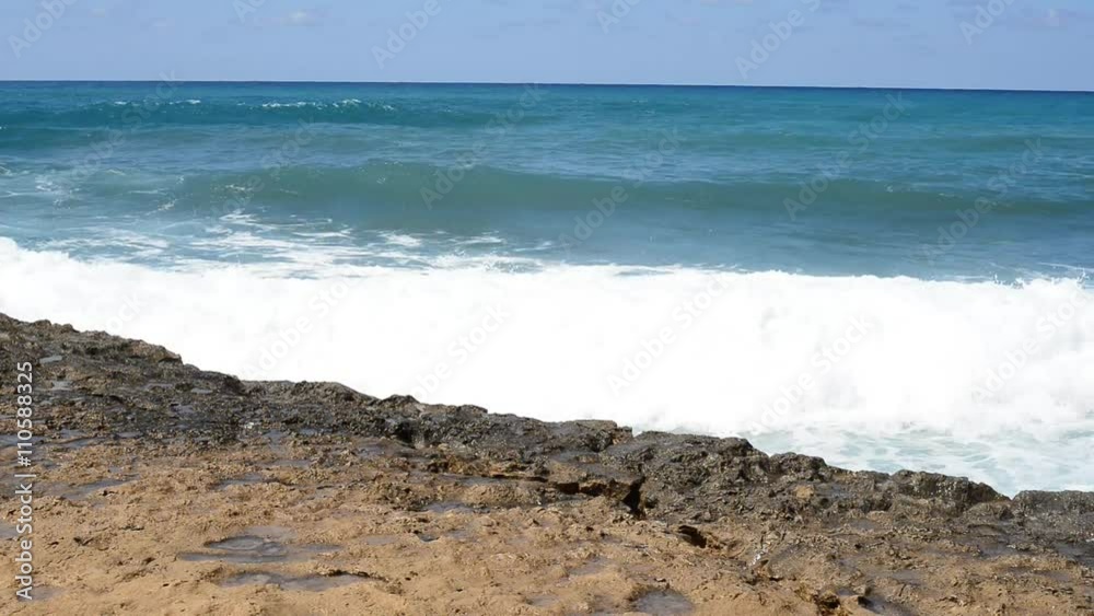 Sea waves splashing near the rocky shore. Sunny day in Cyprus, peninsula Akamas. Sea waves splashing near the rocky shore. Sunny day in Cyprus, peninsula Akamas.