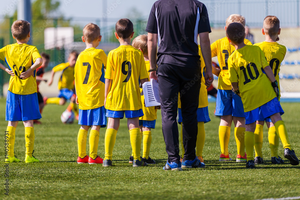 Obraz premium Soccer game. Coach and youth soccer reserve players watching football match.