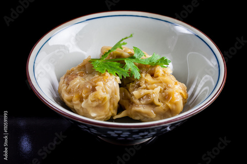 Chinese yum cha, pork dumpling Shumai in white bowl.