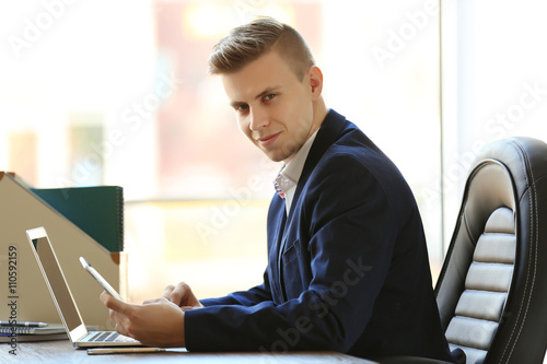 Man using laptop and smart ...