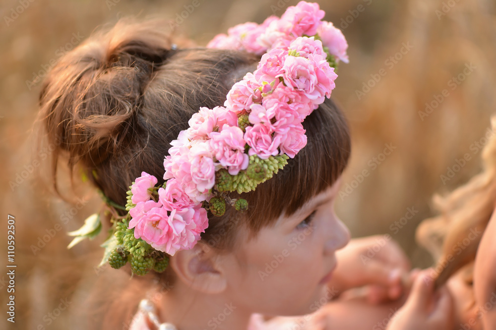 Naklejka premium a wreath of pink roses on the head of a little girl. Profile