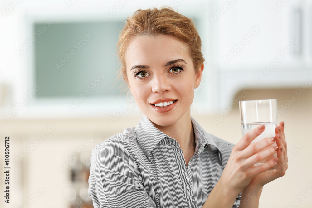 Young woman in the kitchen drinking water Young woman in the kitchen drinking water