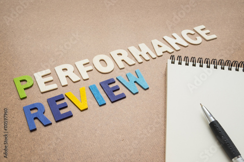 Performance review text with open spiral notebook and pen photo