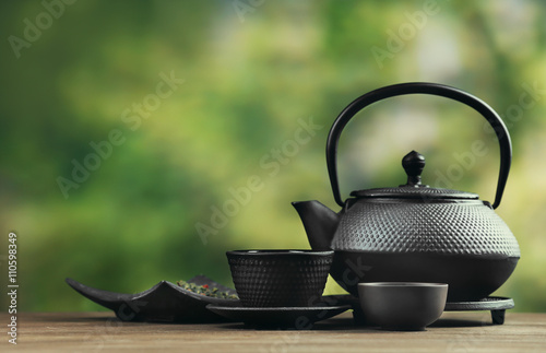 Black pialats and teapot on blurred background