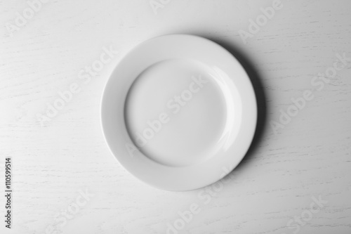 Empty plate on white wooden background