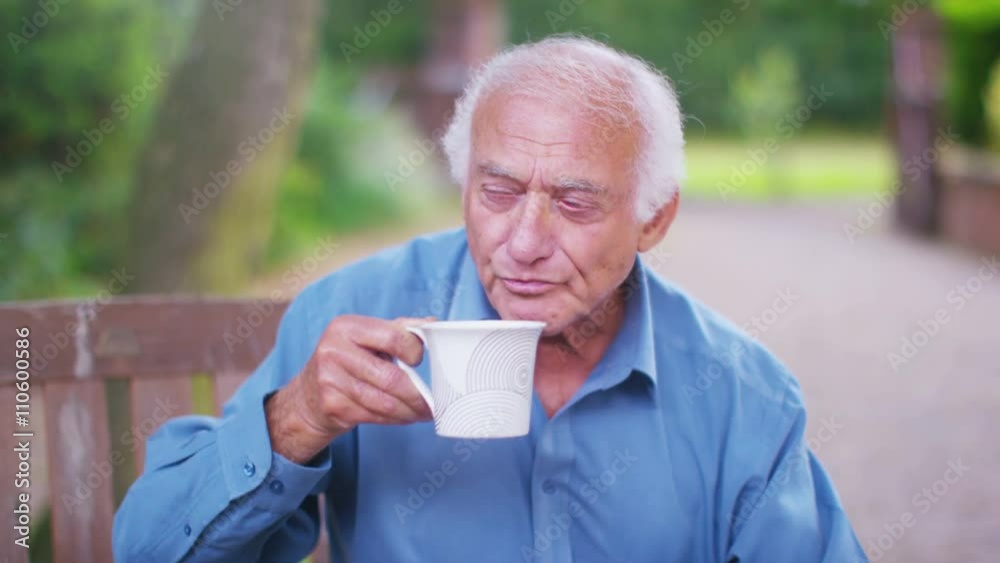 Portrait of cheerful elderly man sitting in the garden with a hot drink Portrait of cheerful elderly man sitting in the garden with a hot drink