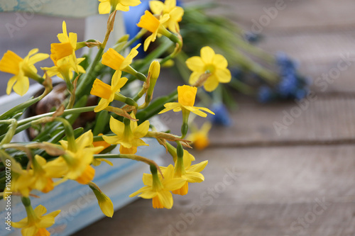 Beautiful narcissus in crate on wooden background