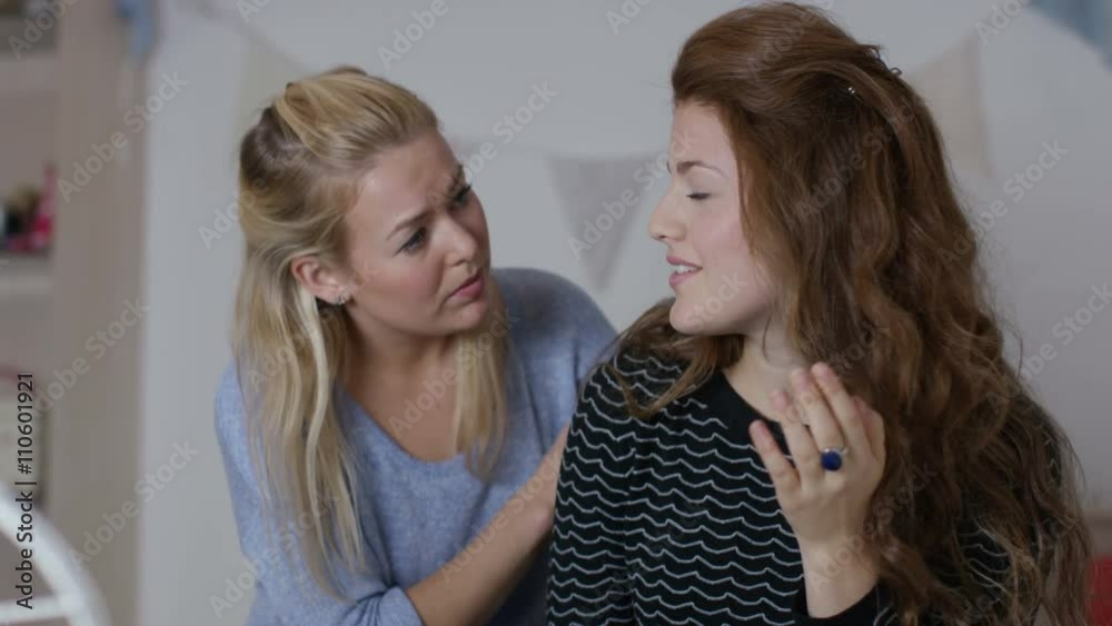 Teenage girls in bedroom, one girl tries to comfort her sad friend Teenage girls in bedroom, one girl tries to comfort her sad friend