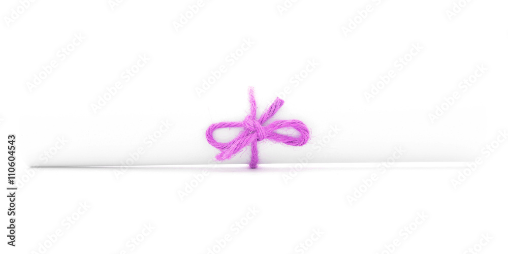 White letter roll tied with string, one pink knot isolated White letter roll tied with string, one pink knot isolated