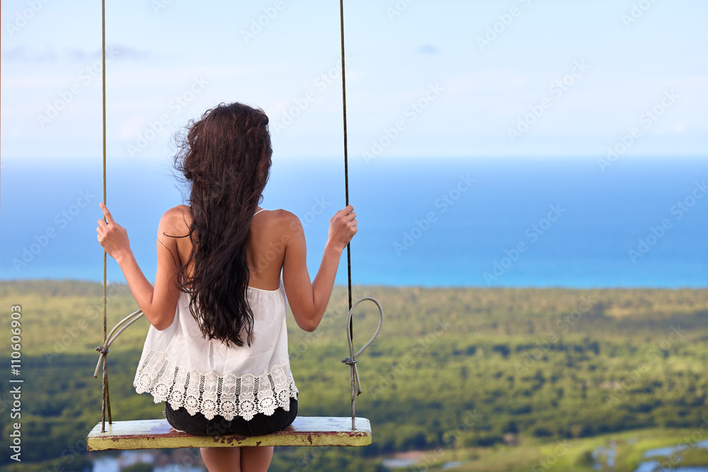 Sea landscape with a girl on swing