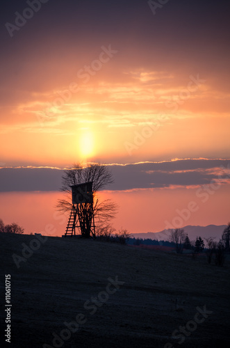 Hunting tower in Carpathian mountains on colorful sunrise
