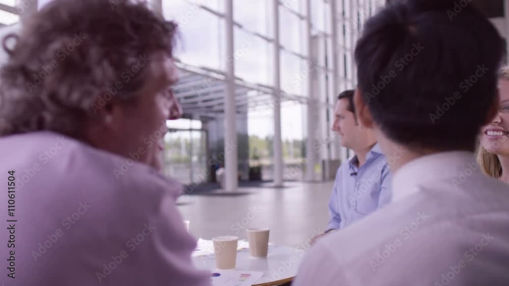Mixed ethnicity business group chatting in large modern office building Mixed ethnicity business group chatting in large modern office building