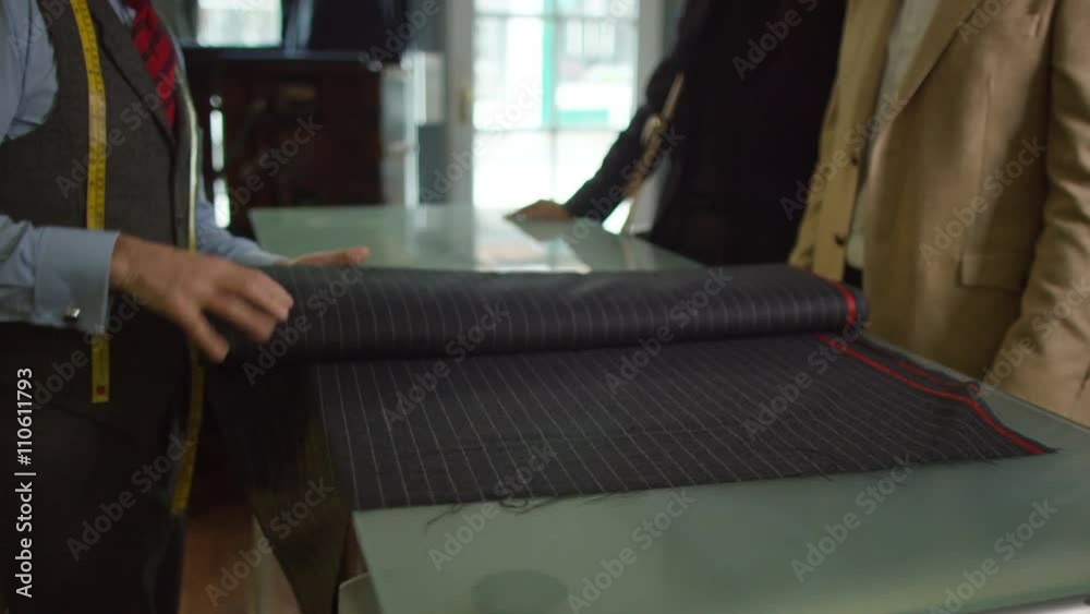 Attractive couple shopping, looking at fabric for new suit Attractive couple shopping, looking at fabric for new suit