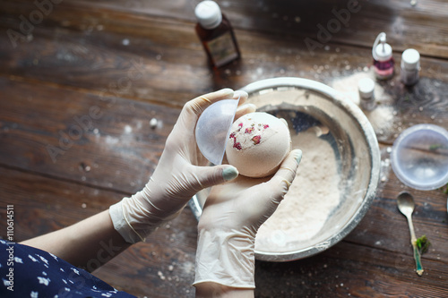 Preparation of bath bombs. Ingredients and floral decor on a wooden vintage table.