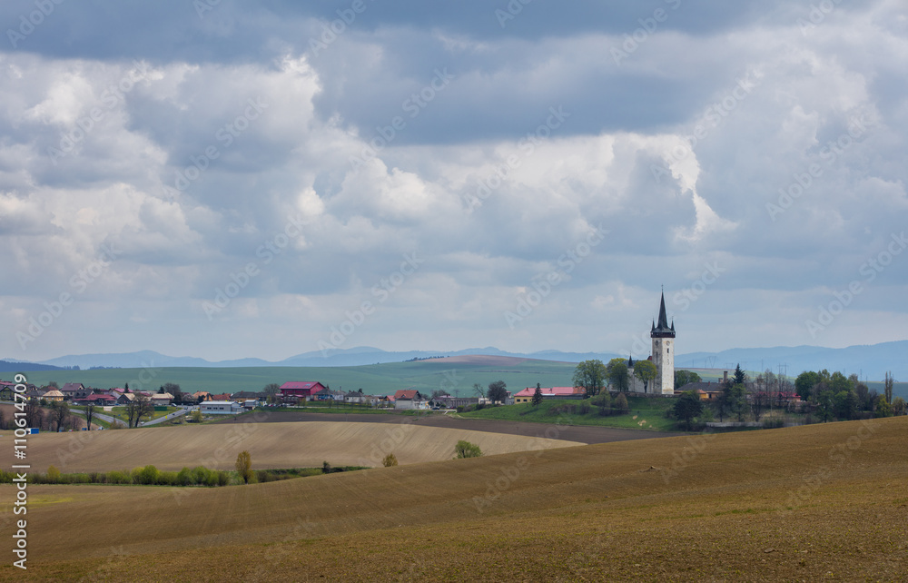 village landscape with old church and clouds