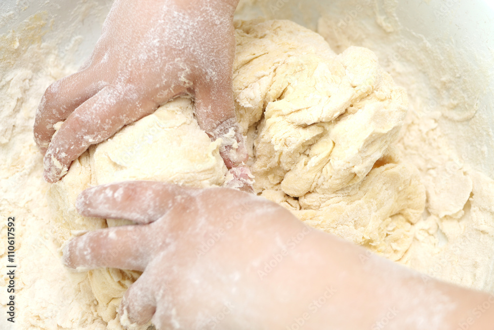 Child hands kneading the dough Child hands kneading the dough