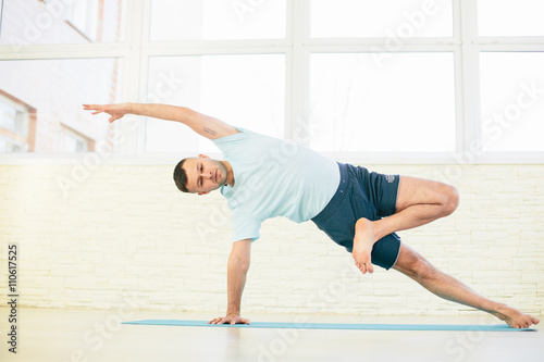 Handsome yoga man practice in a training hall background. Yoga concept.