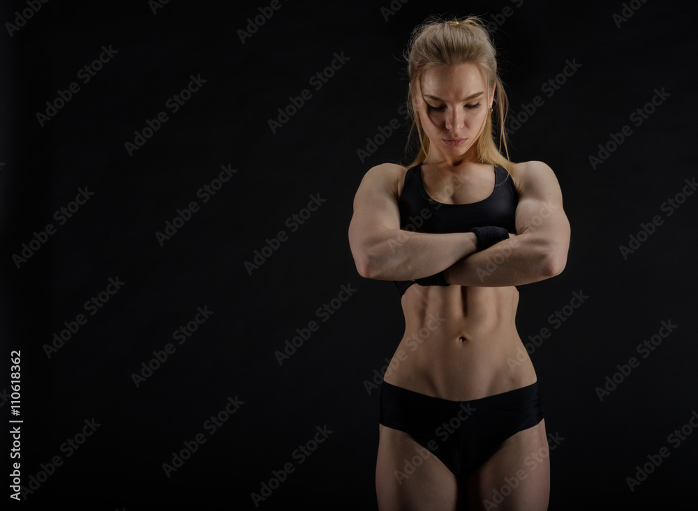 Young muscular woman posing on black Young muscular woman posing on black