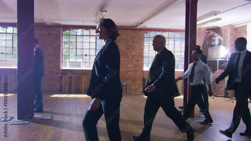 Diverse corporate business team walking through urban industrial building Diverse corporate business team walking through urban industrial building