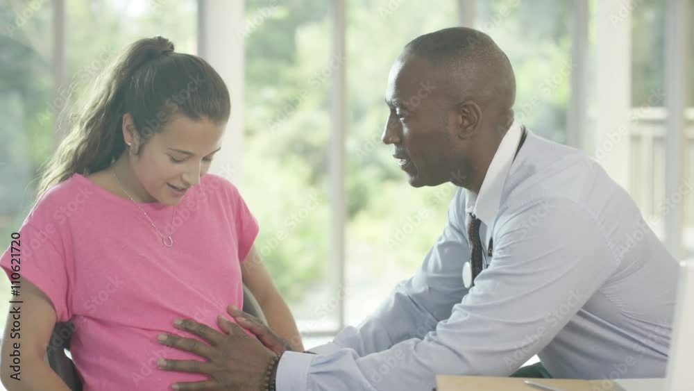  Friendly doctor examining a pregnant woman in office. 