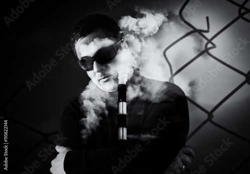 Man in Sunglasses and Industrial Chimney Stack Creative Image