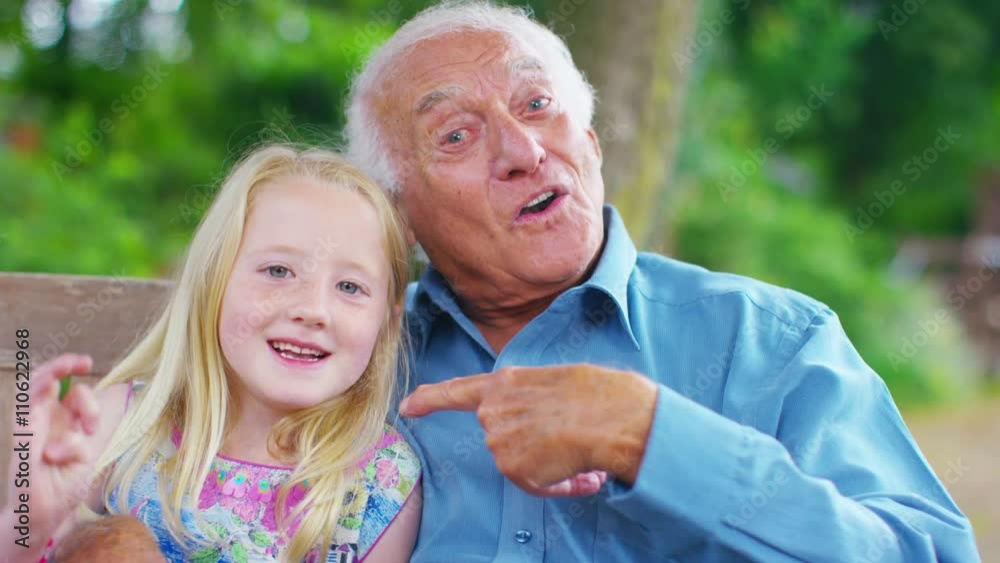 Grandfather & granddaughter make a video call in the garden Grandfather & granddaughter make a video call in the garden