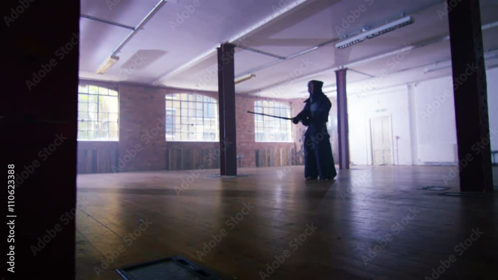  Japanese kendo fighters with bamboo swords competing in dark building