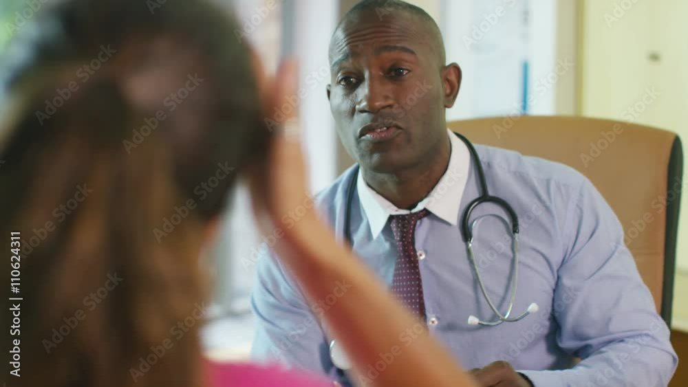  Friendly doctor talking to upset or depressed patient in office