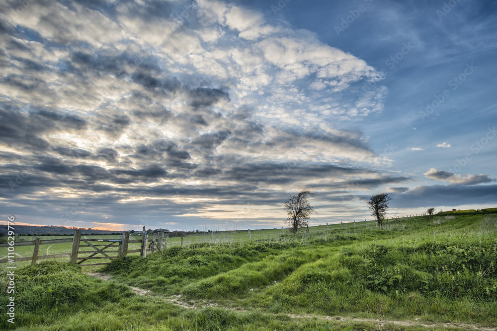 Beautiful English countryside landscape over fields at sunset