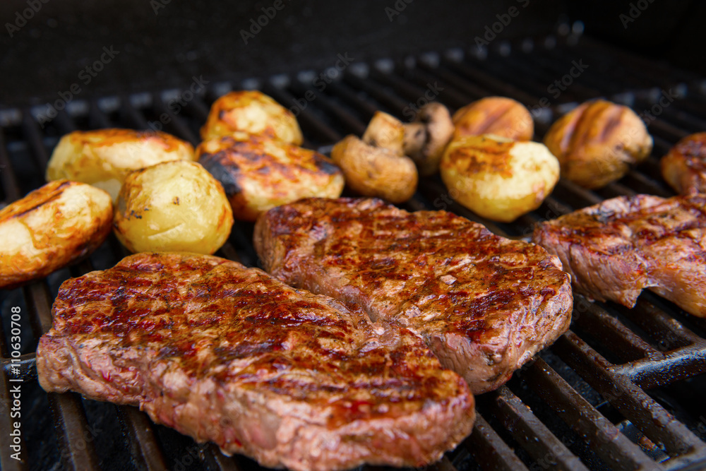 grilled rump steak with mushrooms and potatoes on barbecue