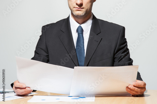 Businessman comparing two documents photo