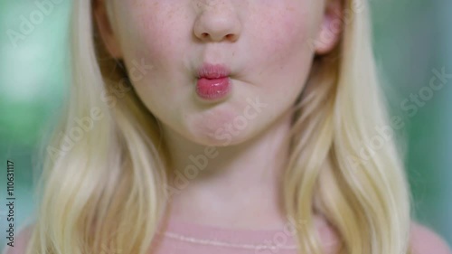  Close up portrait of little girl opening her mouth to show where she has lost one of her baby teeth. 
